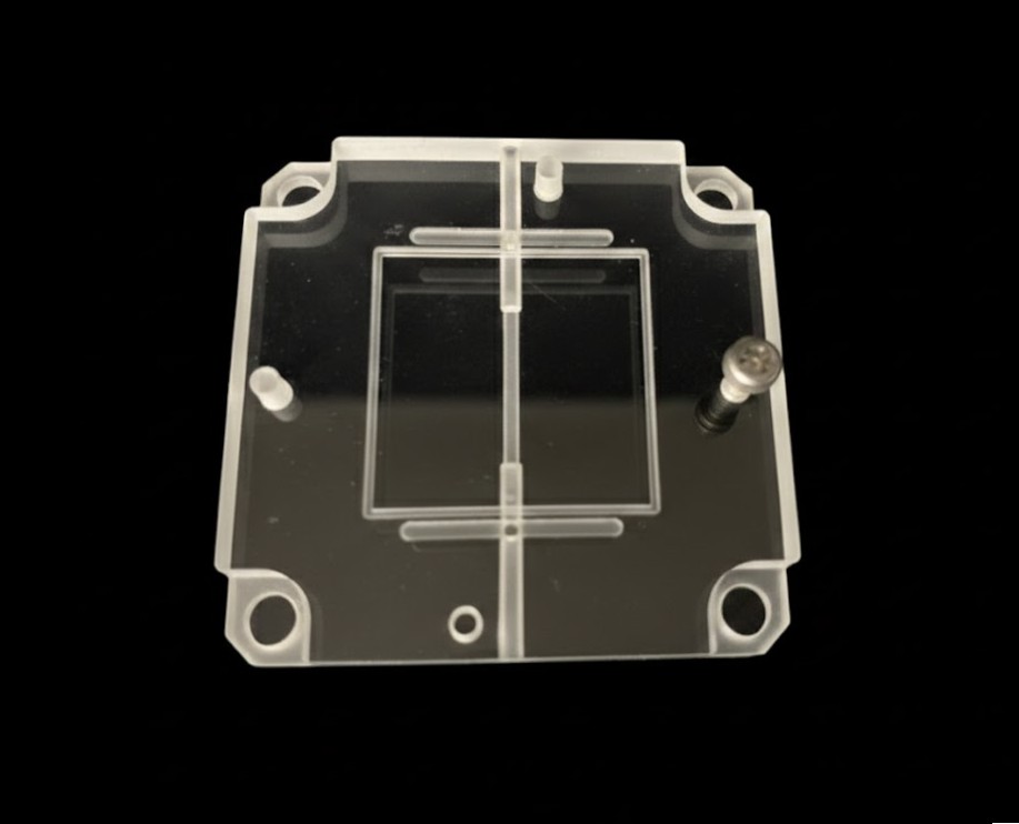 旋盤加工により透明な樹脂(またはガラス)ブロックの側面に精密なネジ切りを施し、ボルト締結を可能にした部品